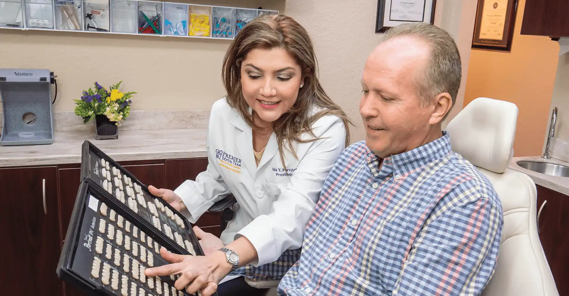Dr. Ada Parra showing a patient a range of tooth colors in a book of porcelain veneers.